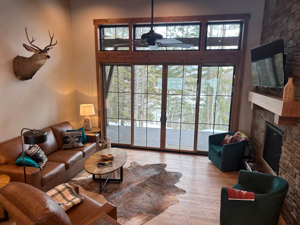 Living area with large picture windows and entrance to the outside deck