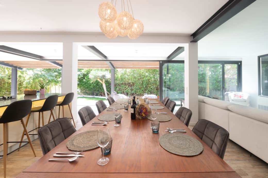 Dining table set beside open kitchen at Casa Guindilla in Portals Nous, Mallorca