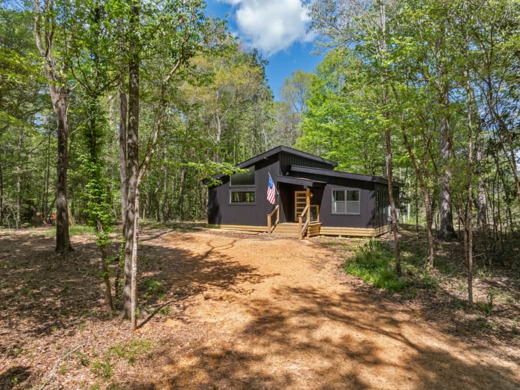 A modern black cabin set privately among the trees, The Fleetwood welcomes you in with clean lines, warm wood accents, and a quiet sense of arrival—subtle nods to its namesake woven throughout, with a touch of rock and roll in the details.
