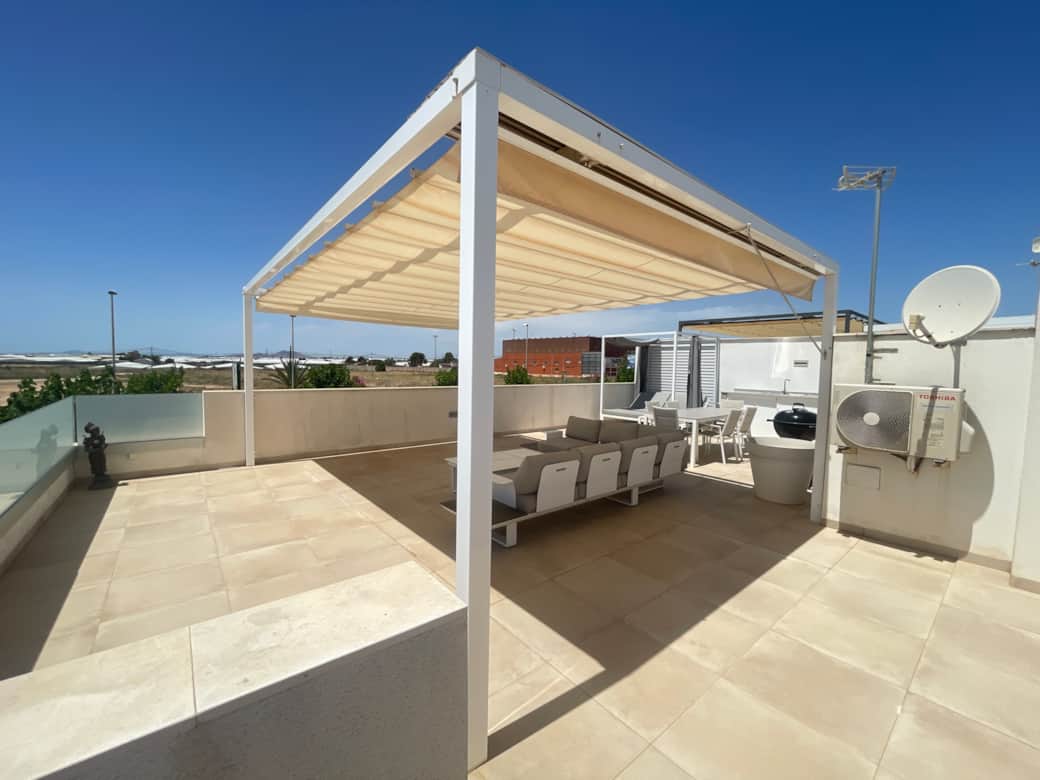 Large, sunny rooftop terrace with a cozy lounge area and sun protection
