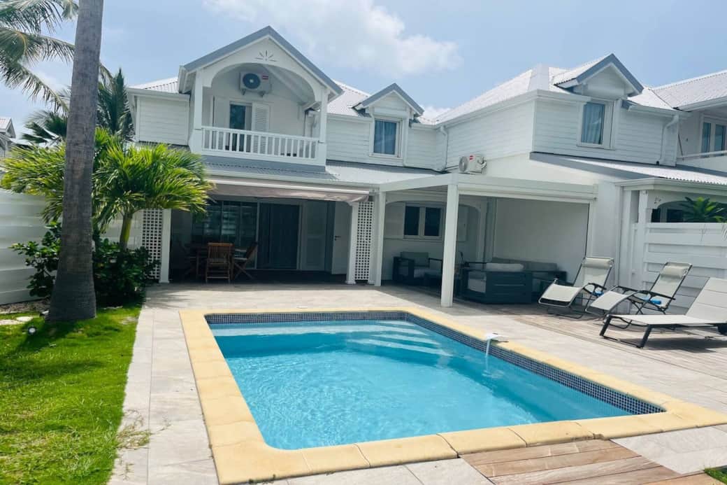 Pool with deck chairs and front of Villa Soliti