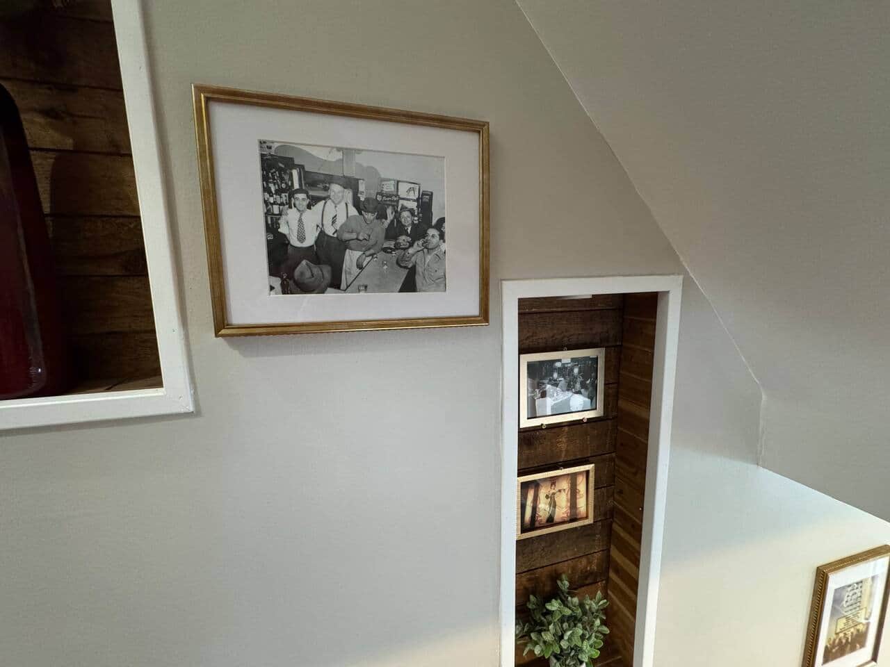 Charming staircase nook featuring curated artwork and warm wood accents