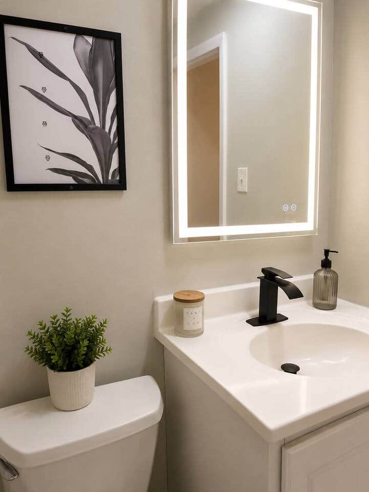 bathroom featuring a full-size bathtub with shower, a sleek illuminated LED mirror, fresh towels, and contemporary finishes. Bright, stylish, and thoughtfully designed, it’s the perfect space to unwind after a day of work or exploring the city