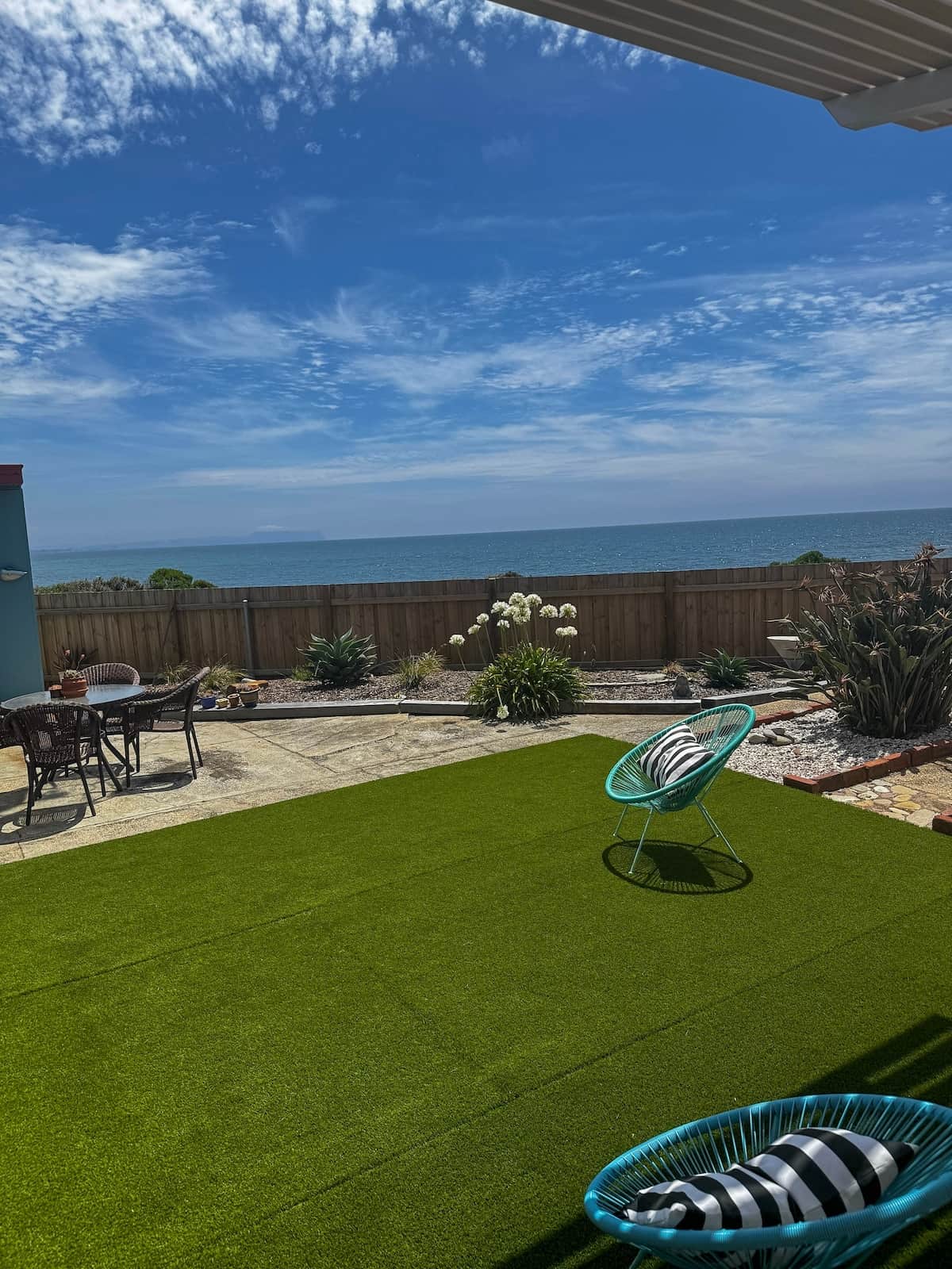 Relaxed outdoor living to fully soak in the sights and sounds of the ocean and coastal pathway over the fence.