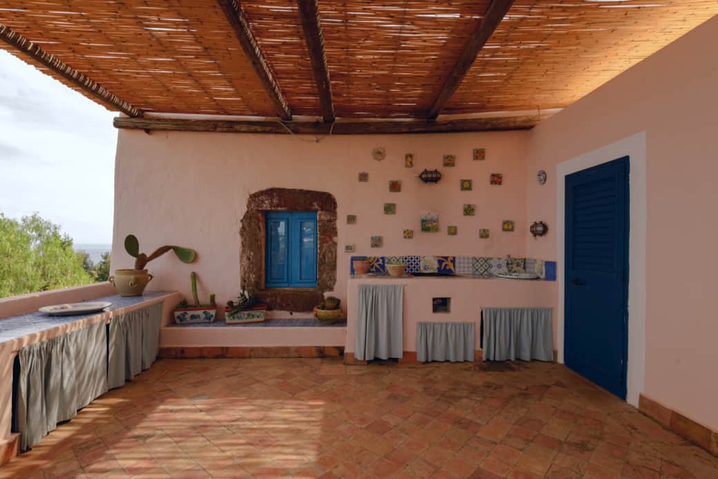 Terrazza coperta in stile eoliano con cucina esterna e vista sul verde di Salina Terrazza coperta in stile eoliano con cucina esterna e vista sul verde di Salina