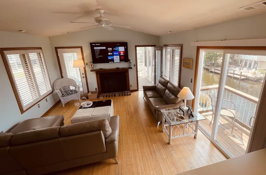 The Family Room with 2 new leather sofas (one with chaise) plus 65" HD Roku TV, balcony, canal view