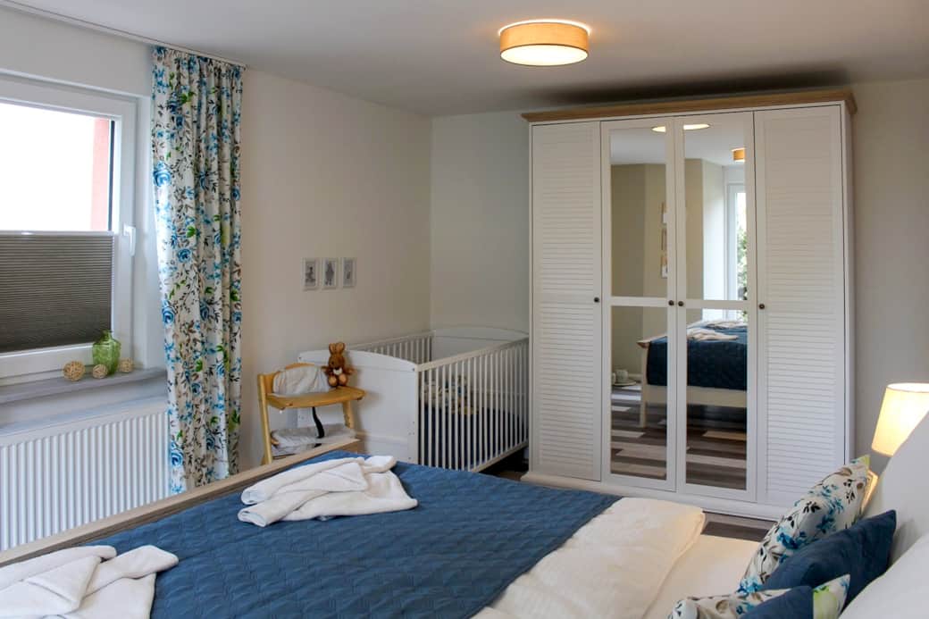 Schlafzimmer mit Doppelbett und Gitterbett
