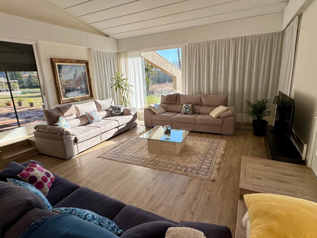 Zona de sofás del salón en la primera planta con vistas al Estanyol y la piscina - Can Guixera