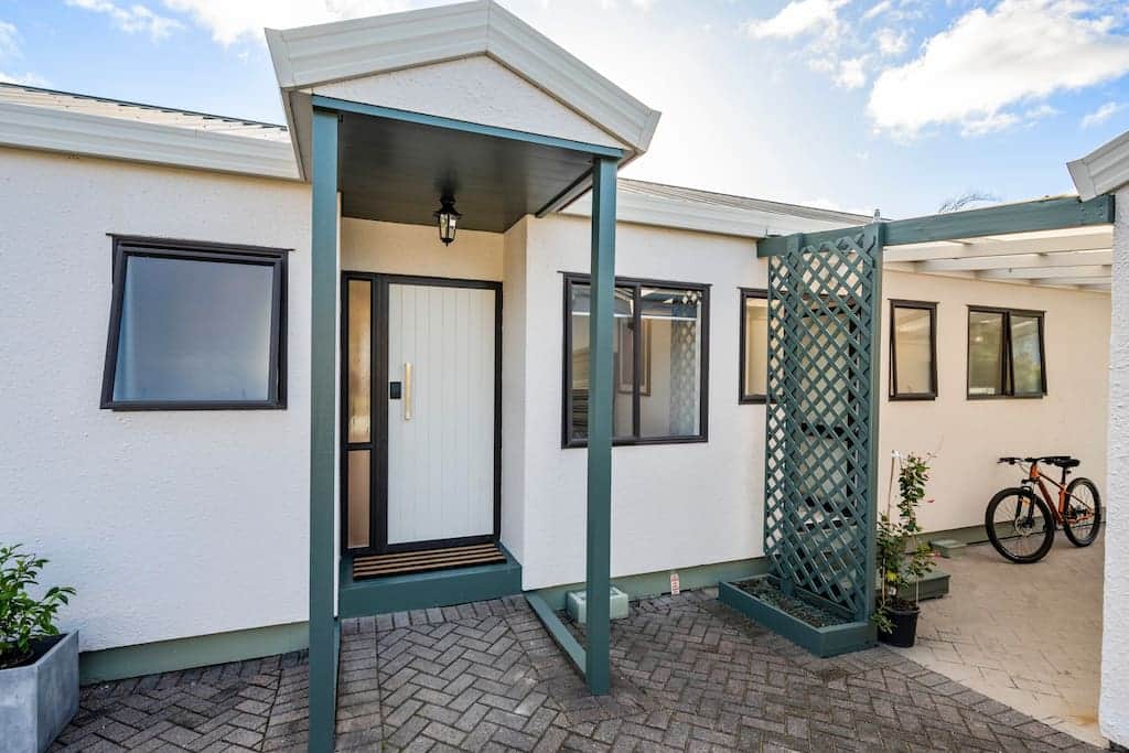 The front of the house features a side covered alcove that connects to the garage. 