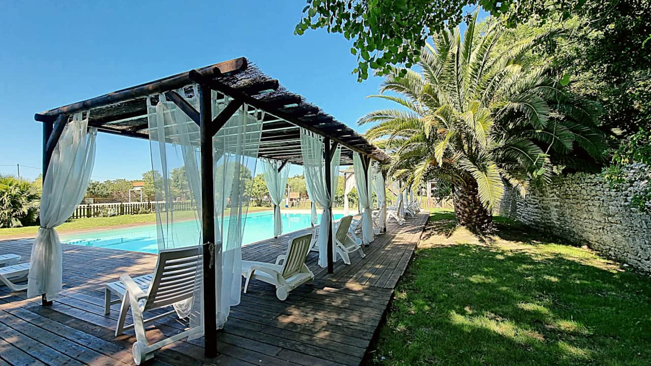 Pérgola de madera con vista a la piscina compartida