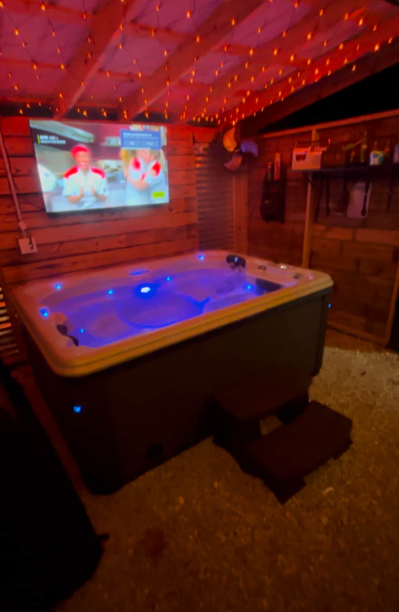 Glowing hot tub situated under a covered pergola 
