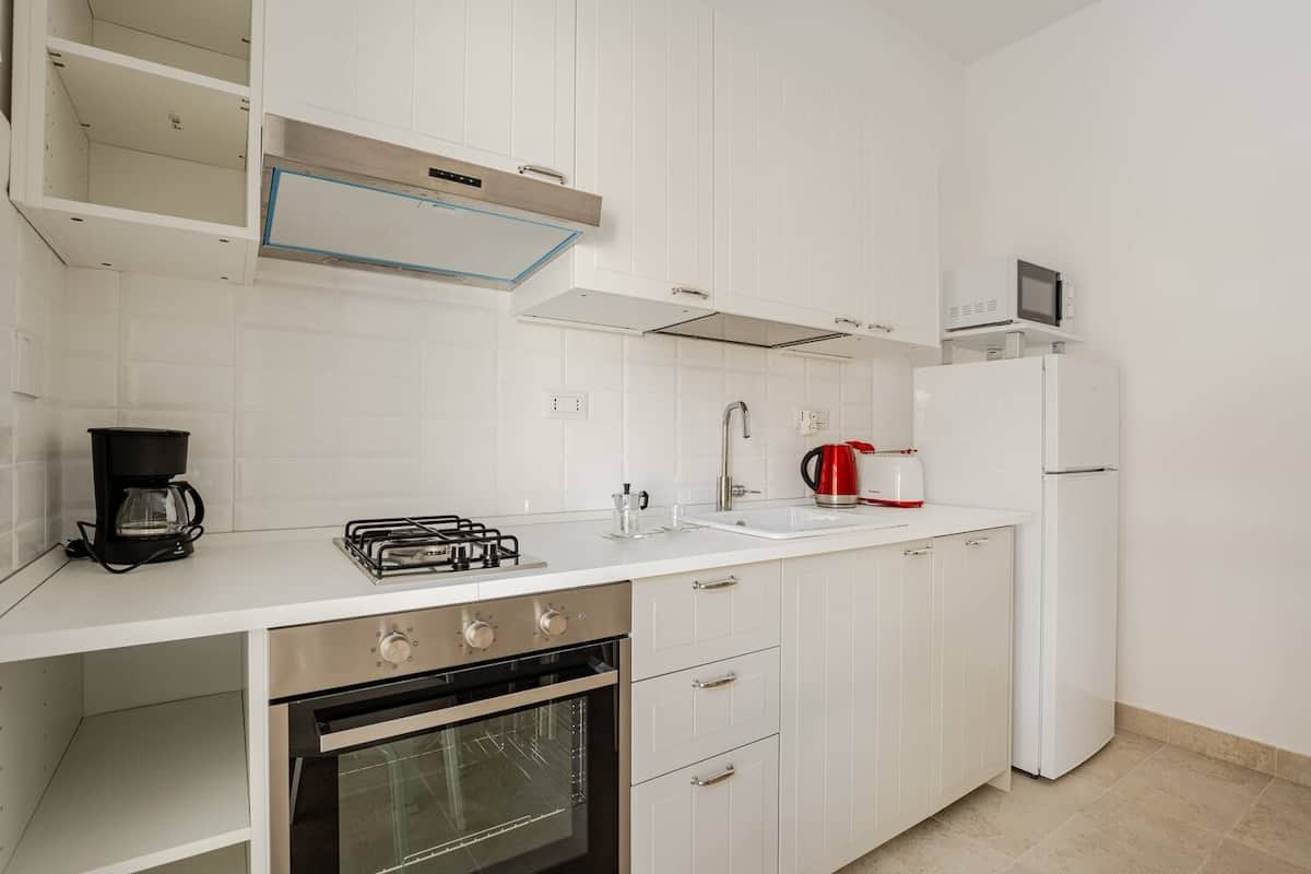 Cucina completamente attrezzata con tavolo da pranzo e accesso al terrazzo.