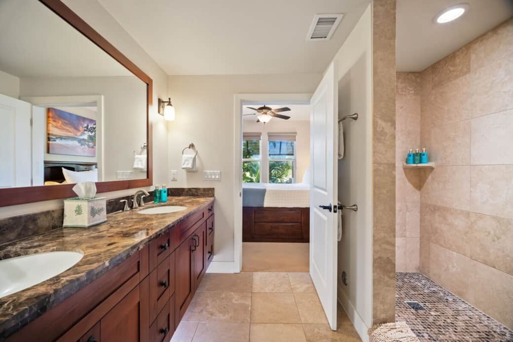 Master bathroom with walk-in shower, dual vanity, and wood-framed mirror