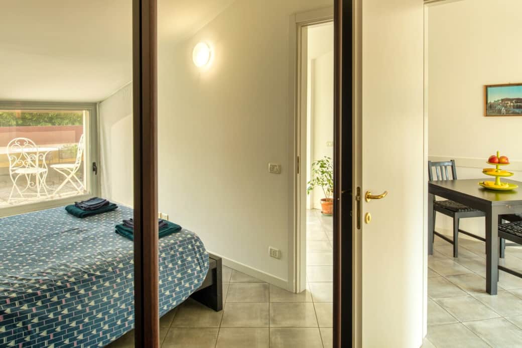 Un affascinante gioco di riflessi nello specchio della camera da letto, che cattura la luce naturale e mostra lo sfondo rilassante della terrazza privata.