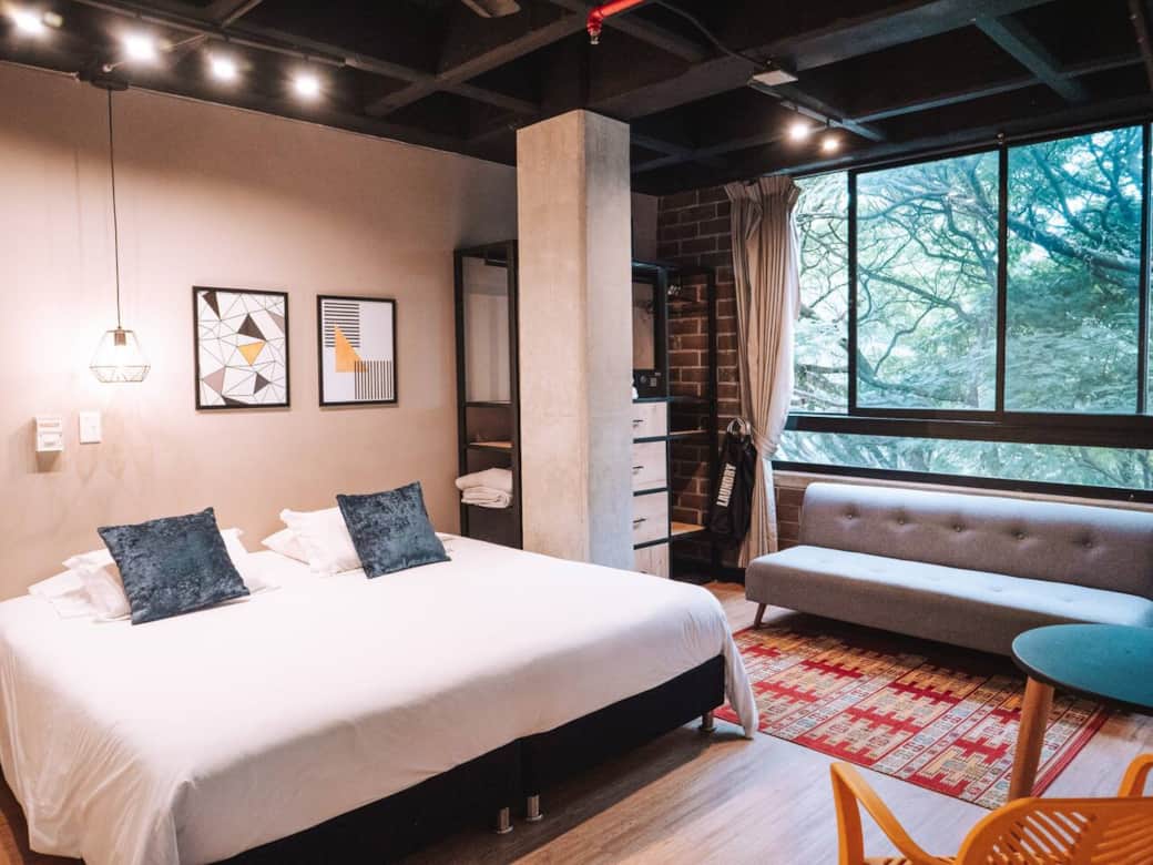 Barato Airbnb en Medellín con ventana hacia la calle con frondoso árbol