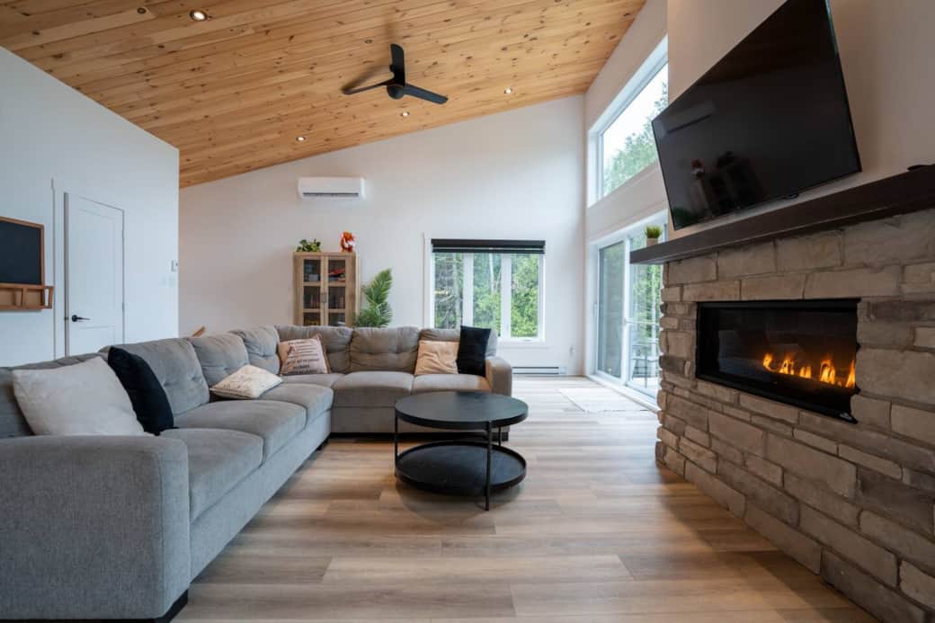 Salon avec foyer au gaz et grande télé intelligente.