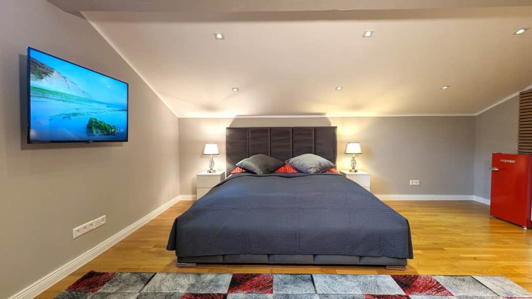 Großes, modernes Zimmer mit komfortablem Doppelbett und harmonischer Beleuchtung