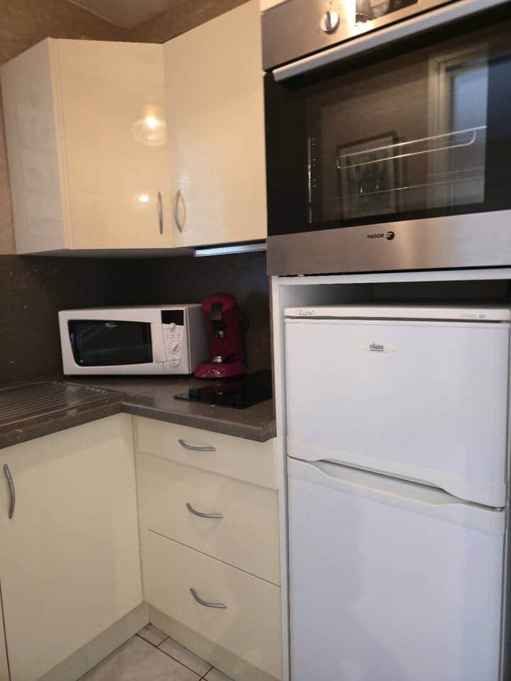 Cuisine complète avec micro-ondes, frigo, plaque, cafetière et rangements. Cuisine complète avec micro-ondes, frigo, plaque, cafetière et rangements.