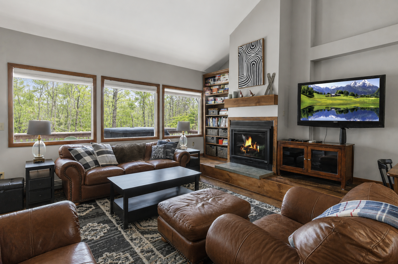 Floor-to-ceiling forest views, fireplace warmth, and cozy four-season mountain retreat vibes