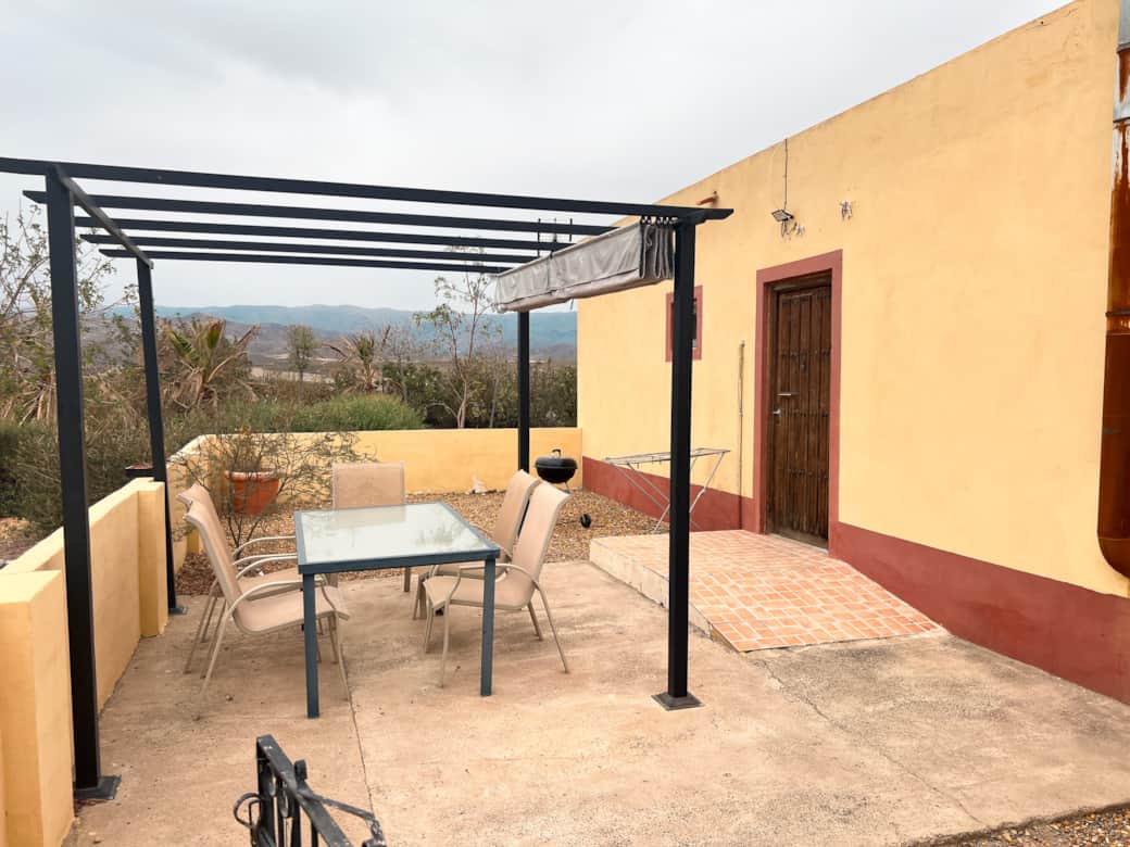 Patio privado con mesa de comedor y parrilla