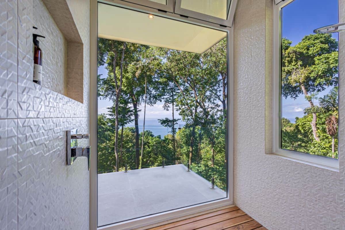 Shower suite with full height glass windows overlooking the ocean and the jungle at Villa Sueño.