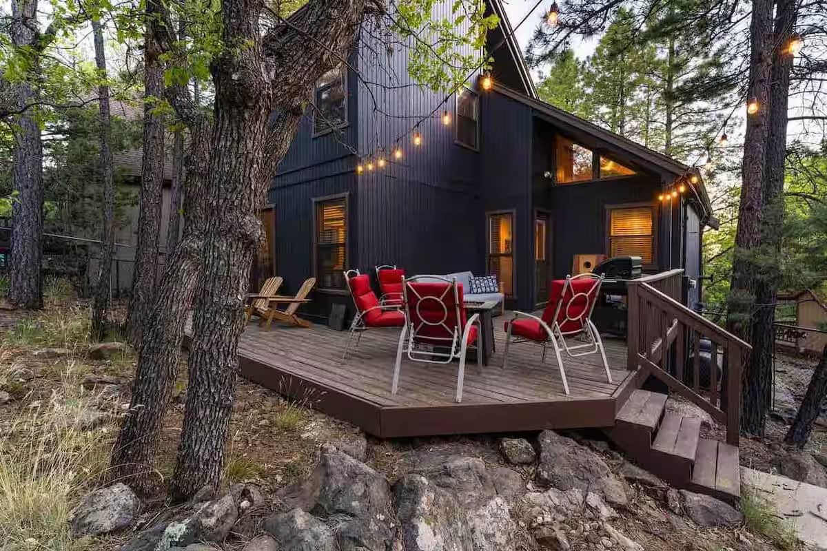 Back deck with seating and string lights at forest cabin near Flagstaff