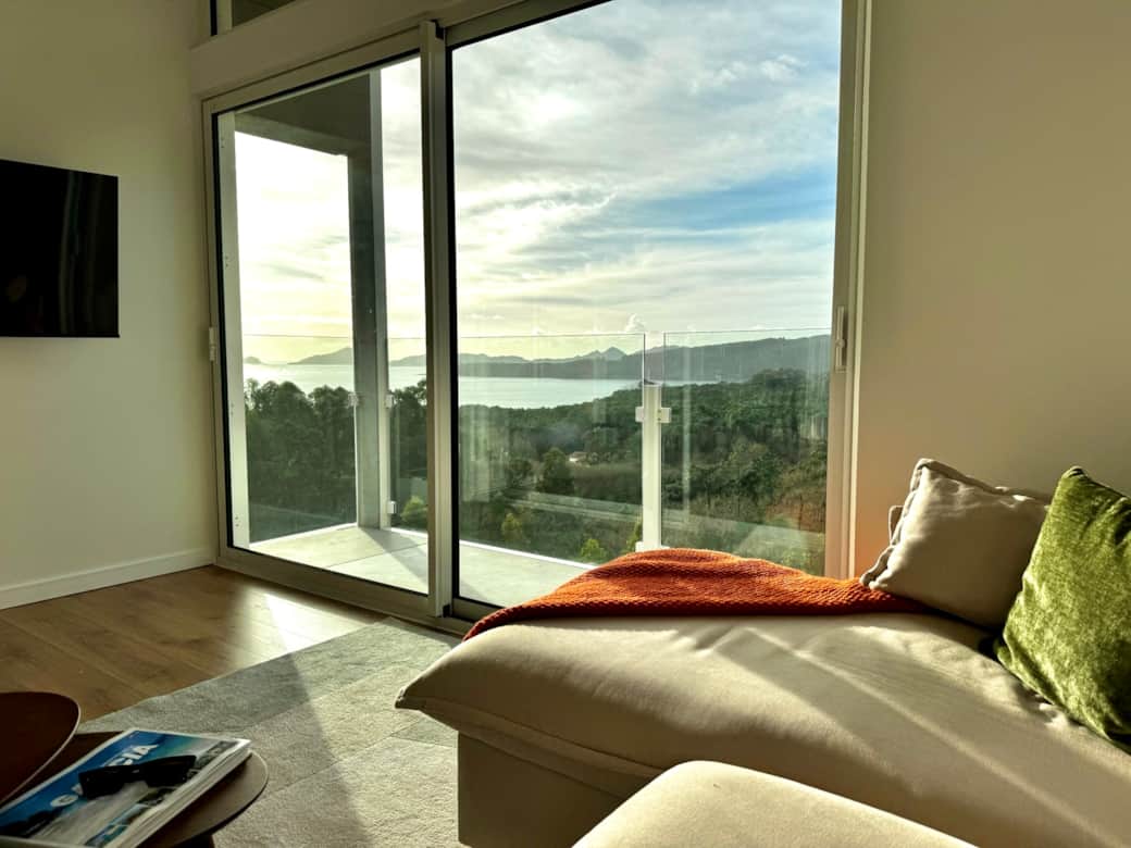 Bright living room with panoramic sea views and balcony overlooking the coast.