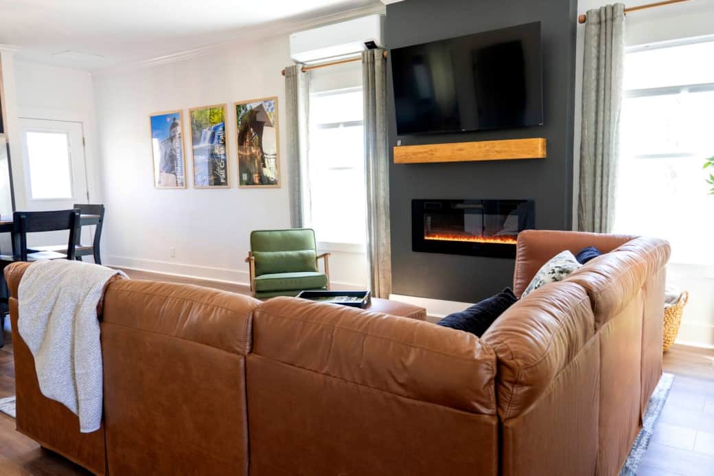 Living room with plenty of seating, 55 inch Roku TV, and electric fireplace.