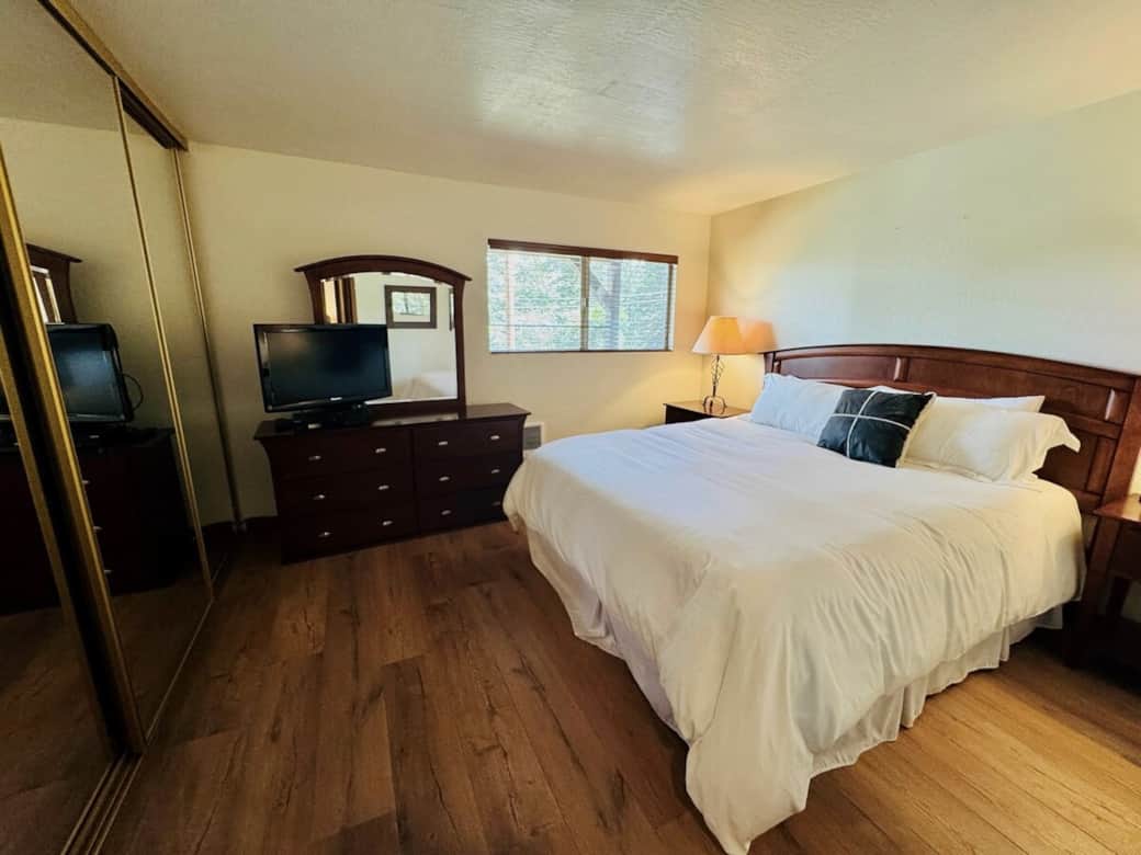 Large main bedroom with private window overlooking open wooded space