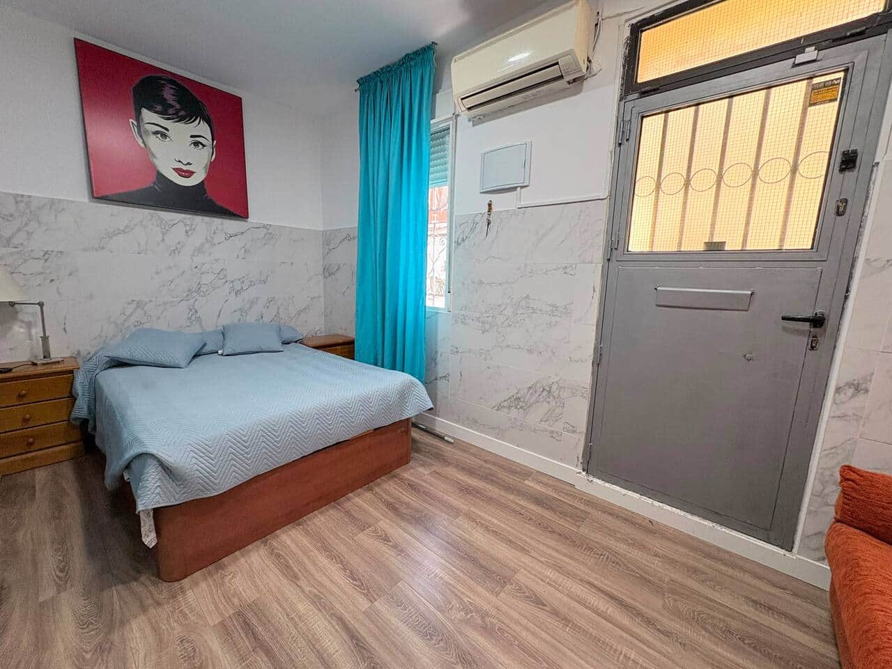 Dormitorio con cama doble y salida a la calle