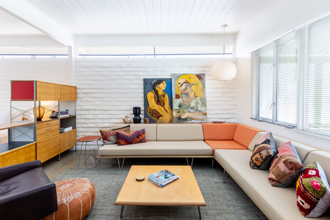 A modern lobby lounge with a sectional sofa, coffee table, and artwork.