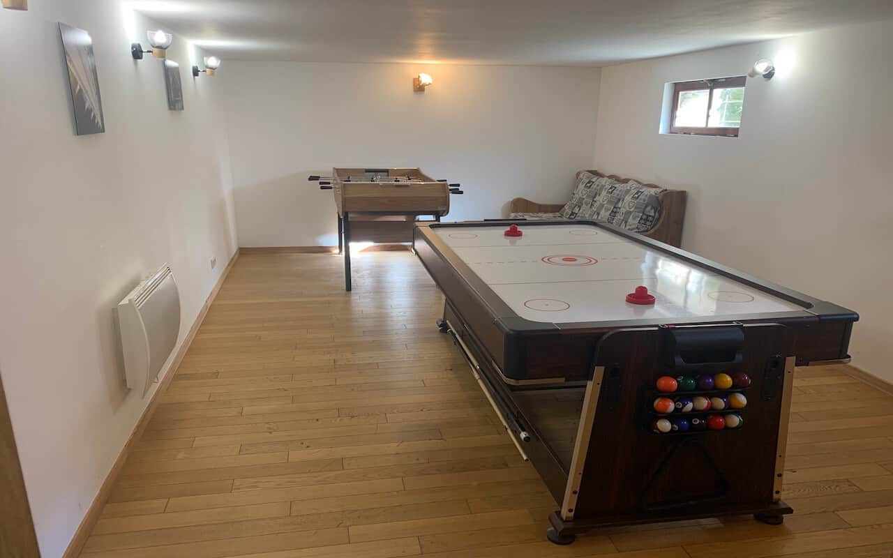 Salle de jeux du Chalet Mont Milo, air hockey en premier plan, billard et baby-foot, Serre Chevalier Vallée