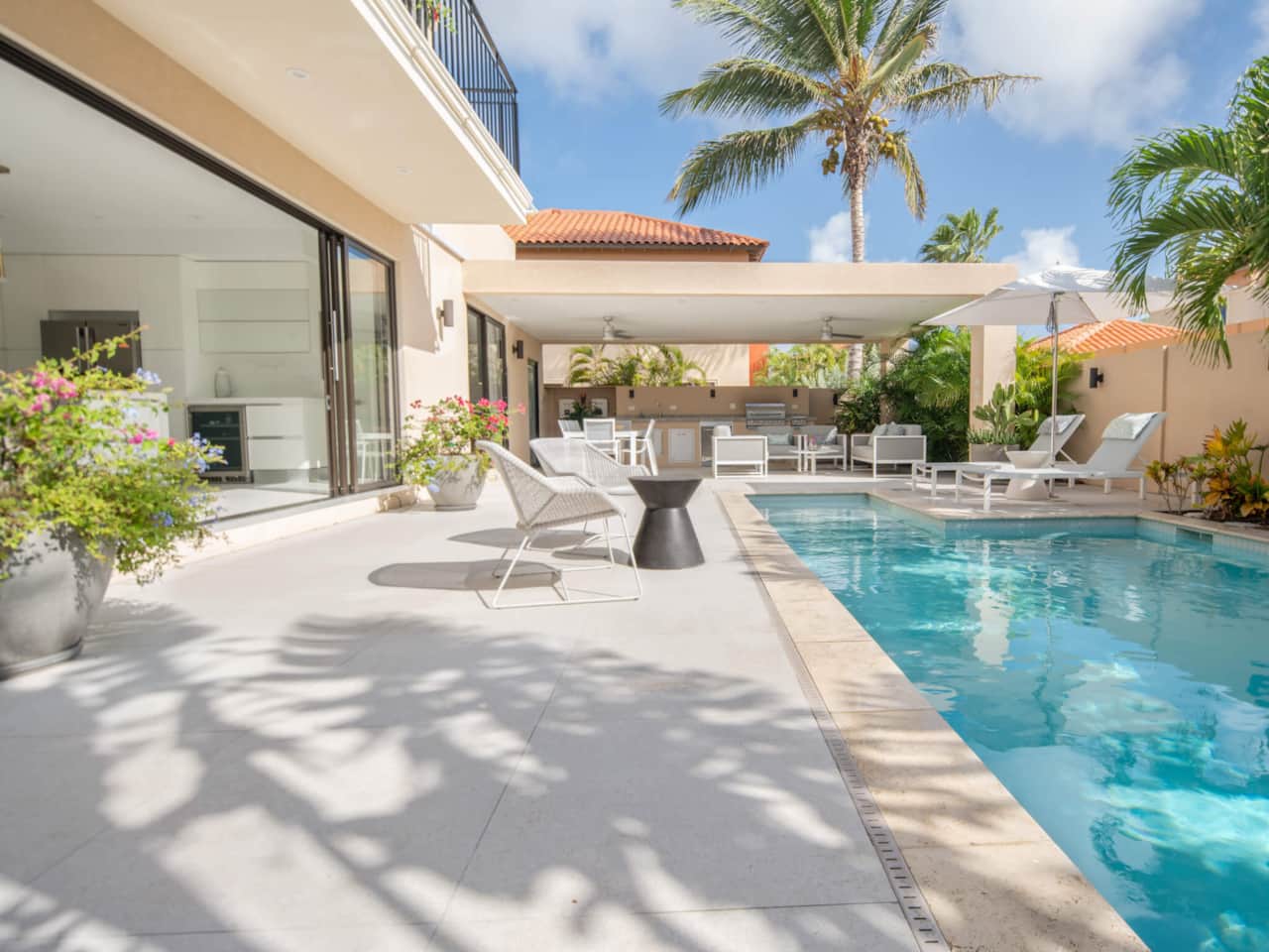 Backyard with private pool, lounging areas, dining table & outdoor kitchen