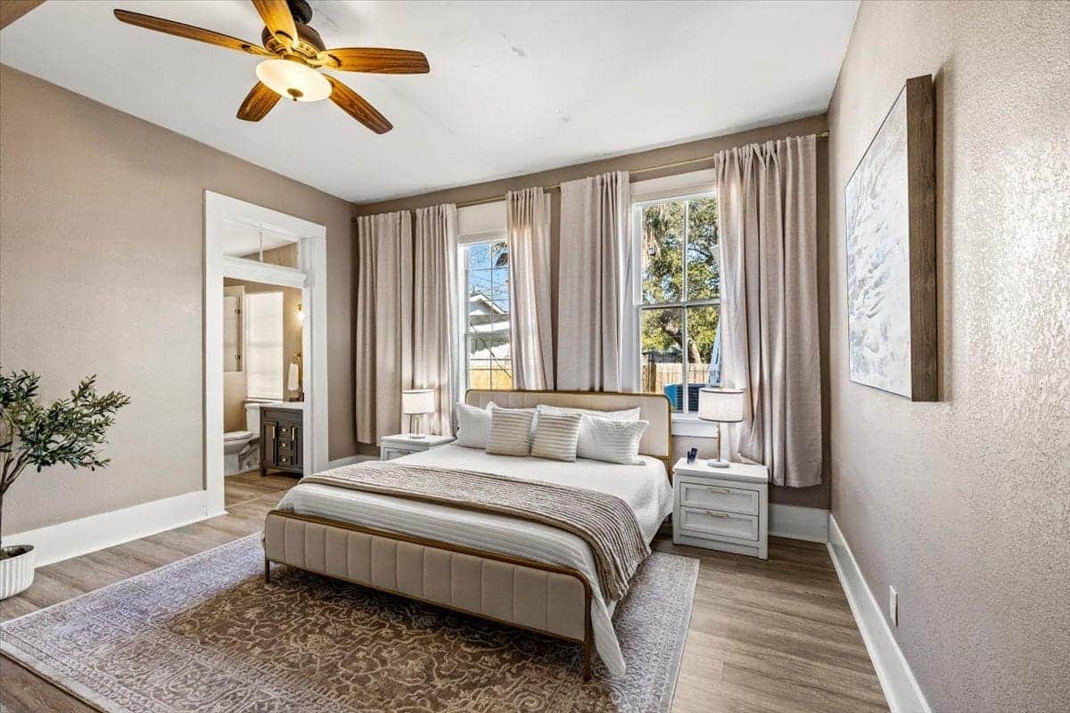 A peaceful 1886 retreat. This elegant primary suite features a plush king bed, high ceilings, and oversized windows that bathe the room in natural light—offering a serene sanctuary after a day of Galveston sun and sand.