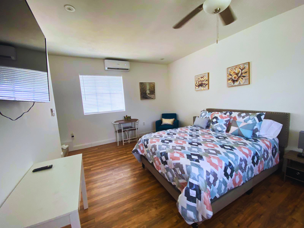 Comfortable room with a queen-size bed, accent chair, desk, and study chair. Lakeland, FL