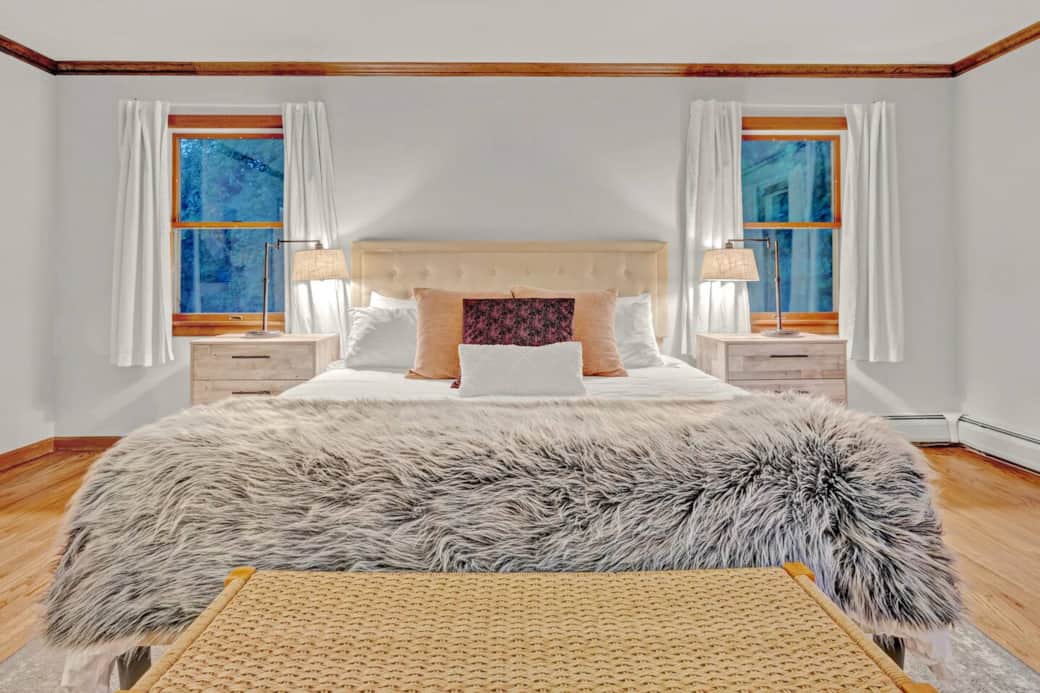 Unwind in the serene master bedroom featuring a plush king bed, soft lighting, and elegant decor. A peaceful retreat designed for rest and relaxation after a day of adventure or quiet moments at home.
