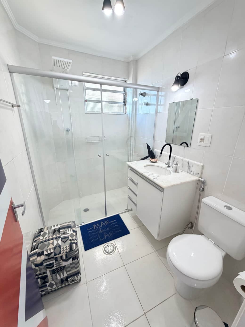 Banheiro amplo com box Blindex, bancada em mármore e excelente iluminação.