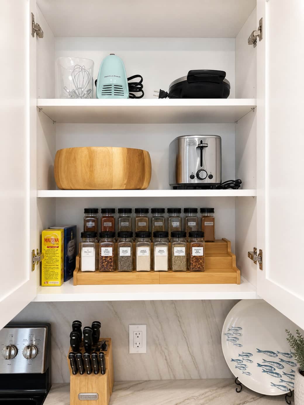 Fully stocked kitchen cabinet with small appliances, spices, and cooking essentials—everything you need to prepare meals with ease