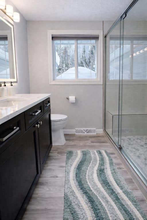 Modern bathroom with walk-in glass shower and cozy cabin-inspired finishes.
