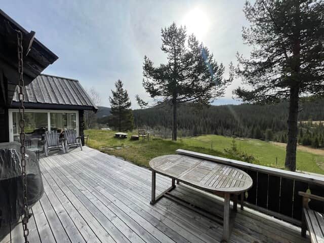 Terrasse med spisebord og benker på tunet
