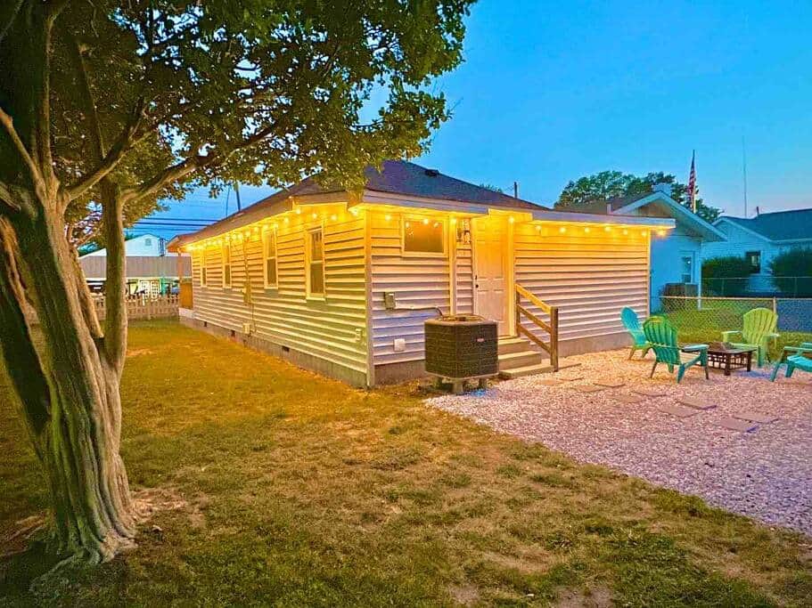 Backyard side view at night with decorative lights &amp; mature trees
