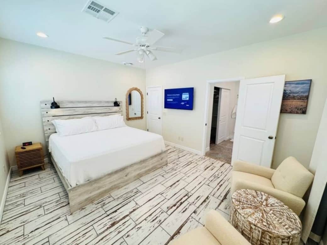 Relax in this spacious haven w/ a plush king bed, soft linens & calming tones. Enjoy your shows on the TV or unwind in the cozy armchairs w/ table. Modern lighting and a ceiling fan add comfort, while the en suite bath offers luxury & convenience.