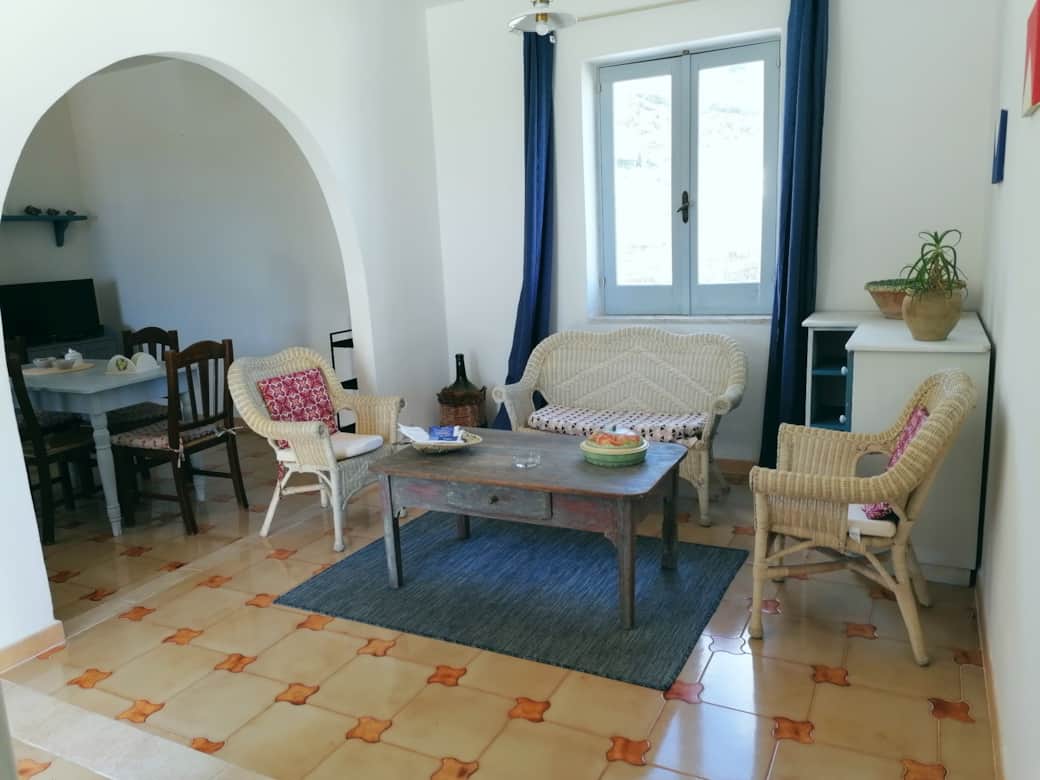 Zona living di Casa Zagami a Malfa, isola di Salina, con salotto e arco interno