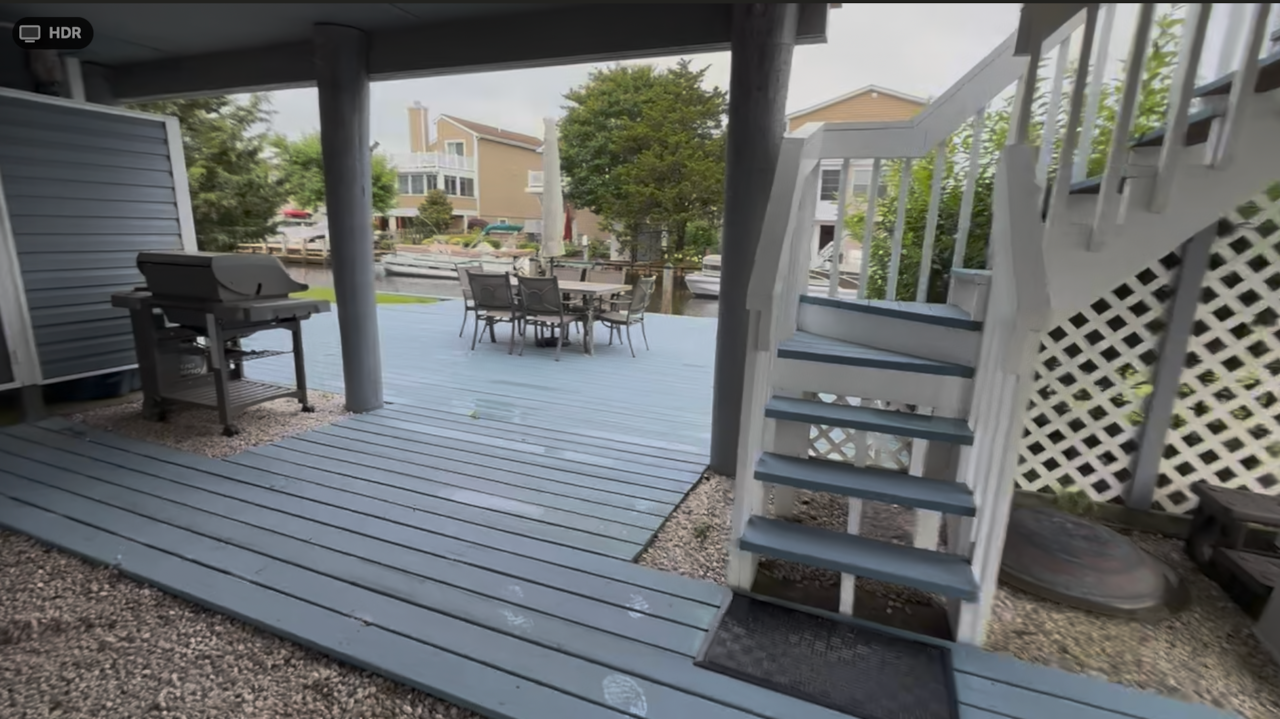 Grill, deck, dock, outside shower with dressing area,  Rear stairs to raised deck/kitchen. 
