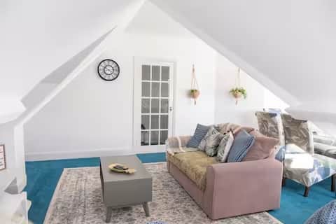 Bright, stylish loft living area with comfortable sofas, Smart TV, and coffee table Bright, stylish loft living area with comfortable sofas, Smart TV, and coffee table