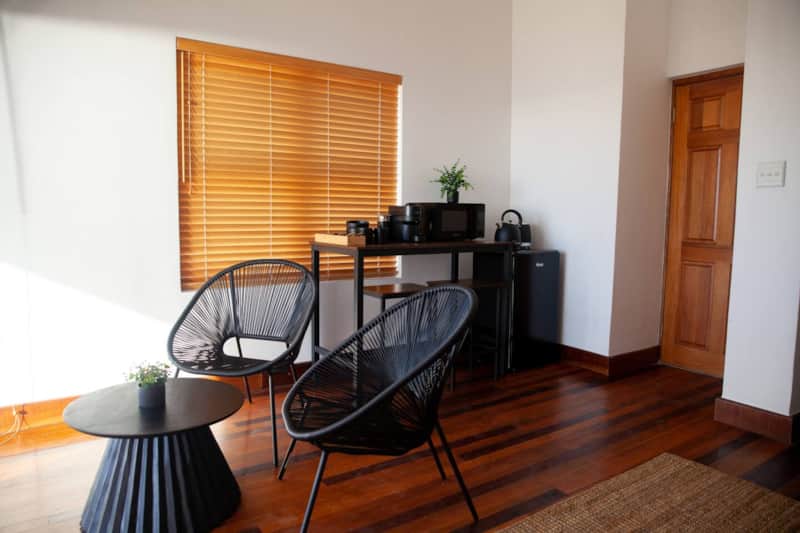 The sitting corner at Seaside Studio, with two chairs, a low table and a kitchenette