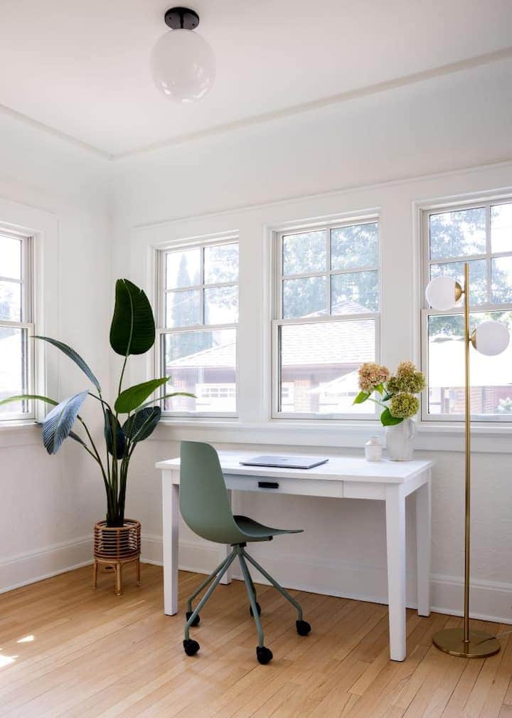 Bright and airy workspace with a dedicated desk, comfortable chair, and large windows 