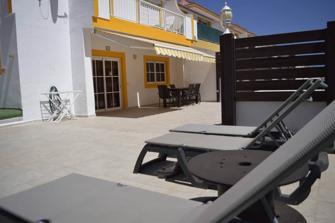 Terraza soleada con tumbonas y toldo