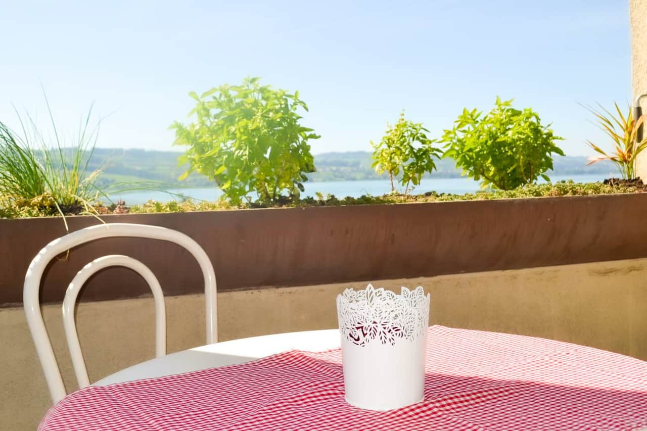 Balkon mit Sonnenstore und Gartentisch und 4 Stühlen, kleinem Liegestuhl und Kräutern zum Gebrauch
