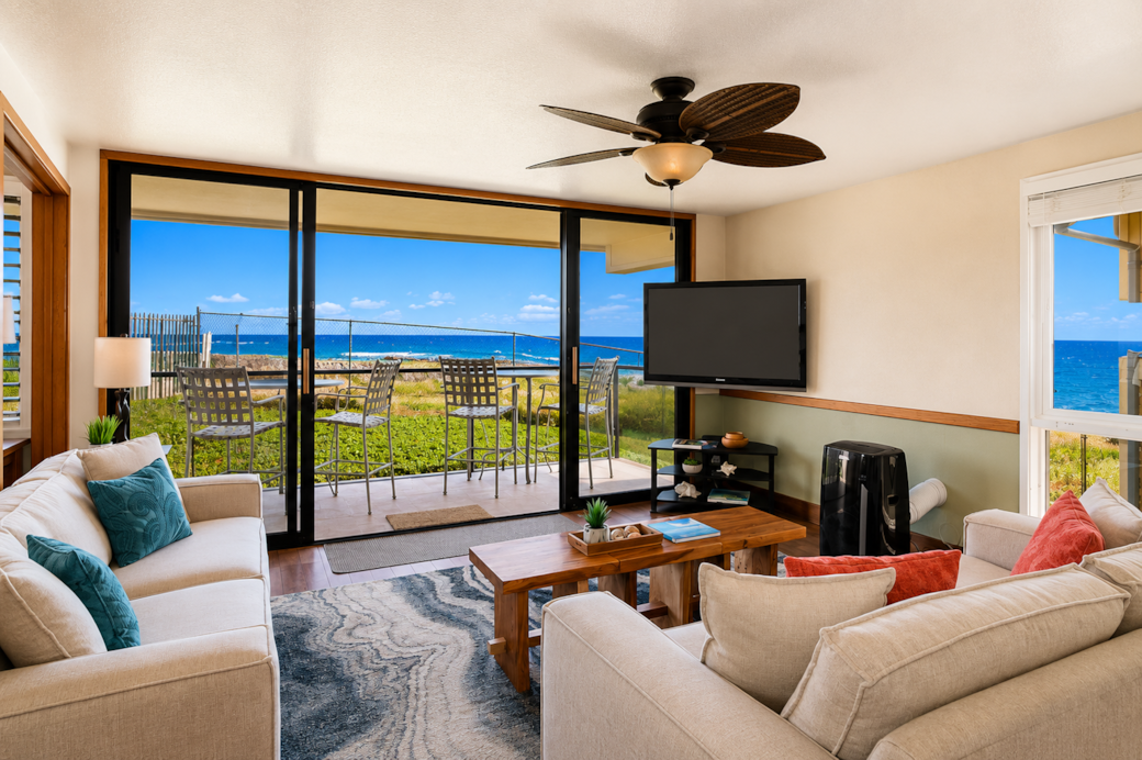 Bright living room with ocean views and lanai access.